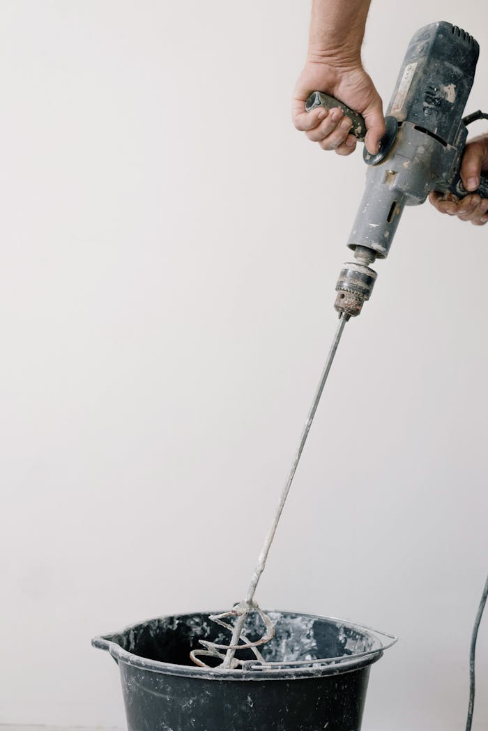 Crafting Captivating Headlines: Your awesome post title goes here Crop unrecognizable male worker holding drill with tool and mixing cement in plastic container