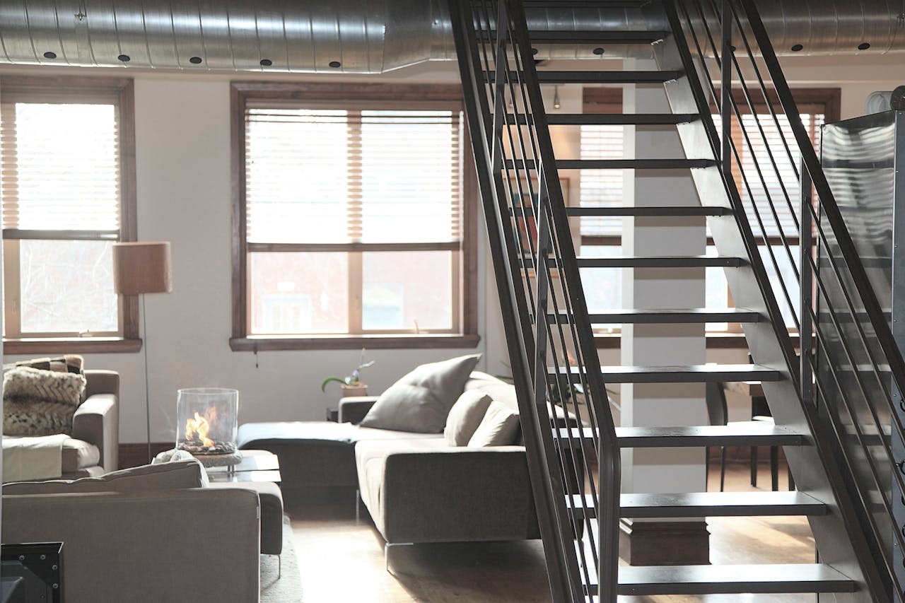 our-experience Bright and modern loft interior featuring cozy furniture and industrial elements, perfect for urban living.